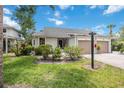 Inviting home with an attached garage, professional landscaping with flowering shrubs, and a green lawn at 7926 Woodpointe Ct # 29, Sarasota, FL 34238