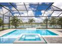 Stunning pool area with a spa and a waterfall overlooking a large serene lake at 8218 Genoa Blvd, Lakewood Ranch, FL 34202