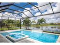 Screened in pool area and spa with a waterfall feature overlooking a beautiful lake at 8218 Genoa Blvd, Lakewood Ranch, FL 34202