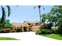 Charming two-story home featuring a lush landscaped yard, circular driveway, and a welcoming front entrance at 9102 12Th Nw Ave, Bradenton, FL 34209