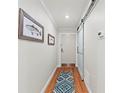 Hallway with wood floors, artwork, and a sliding barn door, creating an inviting entrance at 101 Whispering Sands Dr # 307, Sarasota, FL 34242