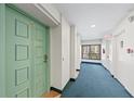 Hallway leading to unit, featuring neutral walls, blue carpet, and an exterior view at 101 Whispering Sands Dr # 307, Sarasota, FL 34242