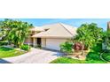 Well-maintained exterior with mature landscaping and a brick driveway leading to a spacious two-car garage at 105 Inlets Blvd # 105, Nokomis, FL 34275
