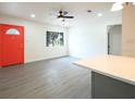Bright living room with light gray flooring, fresh white walls, and a contrasting orange front door at 115 41St Ne Ave, St Petersburg, FL 33703