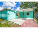 Rear view of home showcasing teal exterior, covered patio, and additional outdoor space at 115 41St Ne Ave, St Petersburg, FL 33703
