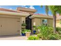 Close-up of front entry with decorative plants, and a brick paver driveway at 11625 Parrotfish St, Venice, FL 34292
