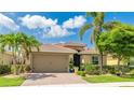 Beautiful single-story home with a well-manicured lawn and mature tropical landscaping at 11625 Parrotfish St, Venice, FL 34292