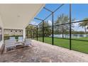 Screened-in lanai with brick flooring and seating area overlooking a serene lake at 12031 Longview Lake Cir, Lakewood Ranch, FL 34211