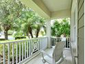 Cozy front porch with chairs, perfect for enjoying a morning coffee or evening sunset with views of trees and greenery at 12331 Halfmoon Lake Ter, Bradenton, FL 34211
