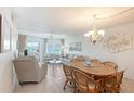 Bright living and dining area featuring waterfront views and a cozy seating arrangement with chandelier at 1350 N Portofino Dr # 402, Sarasota, FL 34242