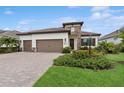Beautiful single-story home featuring a brick driveway, three-car garage, and stone facade accent at 13606 Deep Blue Pl, Bradenton, FL 34211