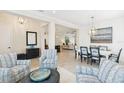 Bright living room with an open floor plan to the dining area with great lighting and plank flooring at 13606 Deep Blue Pl, Bradenton, FL 34211