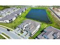 Aerial view of townhomes next to a serene lake, showcasing the community's layout and landscaping at 17715 Boracay Ct # 202, Venice, FL 34293