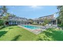 Expansive backyard featuring a sparkling pool, outdoor seating, and lush green lawn at 1774 Cherokee Dr, Sarasota, FL 34239