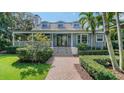 Inviting two-story home with lush landscaping, a brick walkway and classic architectural details at 1774 Cherokee Dr, Sarasota, FL 34239