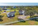 Aerial view of a white home with black shutters, surrounded by green lawns, trees, and a white fence at 2005 21St W St, Palmetto, FL 34221