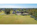 Wide shot of a large property with a well-maintained lawn, white fencing, and mature trees providing shade at 2005 21St W St, Palmetto, FL 34221