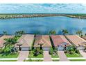 Aerial view of waterfront homes featuring barrel tile roofs in a vibrant lakeside community at 204 Maraviya Blvd, Nokomis, FL 34275
