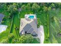 A stunning aerial view of the home, pool, fire pit, and manicured landscaping at 22343 Panther Loop, Bradenton, FL 34202