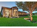 Beautiful exterior featuring a stone facade, arched entryway, lush landscaping, and an inviting walkway at 22343 Panther Loop, Bradenton, FL 34202