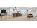 Open-concept kitchen with a large island, modern pendant lighting, and a view into the living space at 2430 Catalonia S Way, St Petersburg, FL 33712
