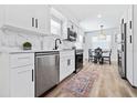Modern kitchen features white cabinets, stainless steel appliances, and a cozy dining area at 3016 Gulf Dr, Holmes Beach, FL 34217