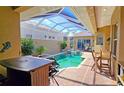 Enclosed backyard pool with a spa, outdoor kitchen, and a seating area at 303 9Th E Ave, Palmetto, FL 34221