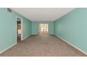 Light-filled living room featuring soft carpeting and light blue walls with sliding glass door at 3072 Lake Bayshore Dr # 119, Bradenton, FL 34205