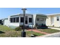 Inviting exterior view of home, highlighting the sunroom, awning, and manicured front yard at 3402 Shingle Oak Ter, Sarasota, FL 34237