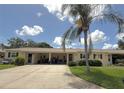 Inviting home with a convenient carport and a lush green lawn with a mature palm tree at 390 301 W Blvd # 2C, Bradenton, FL 34205