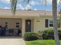 Close-up of front door of home surrounded by a tropical landscaped yard and a covered car port at 390 301 W Blvd # 2C, Bradenton, FL 34205