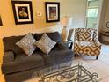 Cozy living room featuring a comfortable gray sofa, patterned accent chair, and stylish decor at 390 301 W Blvd # 2C, Bradenton, FL 34205