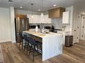 Modern kitchen featuring an island with a marble countertop, stainless steel appliances, and pendant lighting at 4460 Emerald Ridge Dr, Sarasota, FL 34233