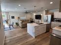 Open-concept living space with a kitchen island, dining table, and comfortable seating area at 4460 Emerald Ridge Dr, Sarasota, FL 34233