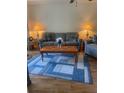 Living room with wood laminate flooring, sofa, and modern area rug at 4520 47Th W Ave # 103, Bradenton, FL 34210