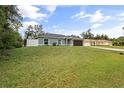 Inviting home with lush green lawn and charming facade, including an attached garage at 4565 Eldron Ave, North Port, FL 34286