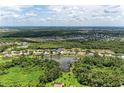 Aerial view of a neighborhood with houses surrounding lakes and lush green trees and foliage at 5359 90Th Avenue E Cir, Parrish, FL 34219
