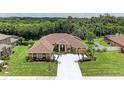 Expansive aerial view of a single-story home with a large lot, mature trees, and a long driveway at 5359 90Th Avenue E Cir, Parrish, FL 34219