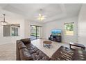 Bright living room featuring tile floors, a ceiling fan, and sliding glass doors to the lanai at 5584 Eastwind Dr, Sarasota, FL 34233