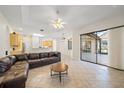 Open-concept living room with tile flooring, ceiling fan, and views into the kitchen at 5584 Eastwind Dr, Sarasota, FL 34233