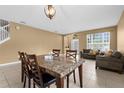 Open-plan living and dining area featuring large windows and neutral tile flooring at 5981 Willows Bridge Loop, Ellenton, FL 34222