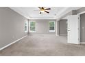 Spacious main bedroom featuring neutral paint, plush carpet, and tray ceiling at 5981 Willows Bridge Loop, Ellenton, FL 34222