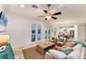 Comfortable living room with a ceiling fan, tile floors, and French doors that provide natural light and access to the outdoors at 634 Key Royale Dr, Holmes Beach, FL 34217
