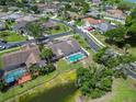Aerial view of a home with a screened-in pool, landscaped yard and nearby pond within a neighborhood at 6405 Alesheba Ln, Sarasota, FL 34240