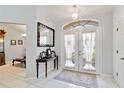 Inviting foyer with tiled floor, arched window, and decorative mirror creating an elegant entryway at 6405 Alesheba Ln, Sarasota, FL 34240
