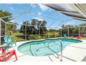 Screened in backyard pool with seating area, lush landscaping, and ample space for entertaining at 6405 Alesheba Ln, Sarasota, FL 34240