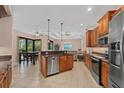 Open concept kitchen featuring wood cabinets, stainless steel appliances, and a breakfast bar with a view of the living room at 6528 Coopers Hawk Ct, Lakewood Ranch, FL 34202