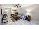 Cozy living room with tile floors, ceiling fan, and a nautical-themed rug under the coffee table at 6860 Whitman Ct # 32B, Sarasota, FL 34243