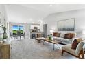 Bright open-concept living room with vaulted ceilings, neutral decor, and seamless flow to the kitchen and dining at 7295 Donahue St, Port Charlotte, FL 33981