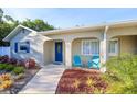 Welcoming front entrance with a vibrant blue door, blue shutters and charming outdoor seating at 8007 17Th Nw Ave, Bradenton, FL 34209